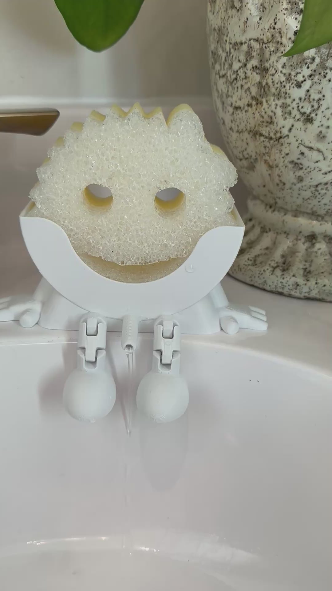 Video showing Little Dripper sponge holder draining water in kitchen sink
