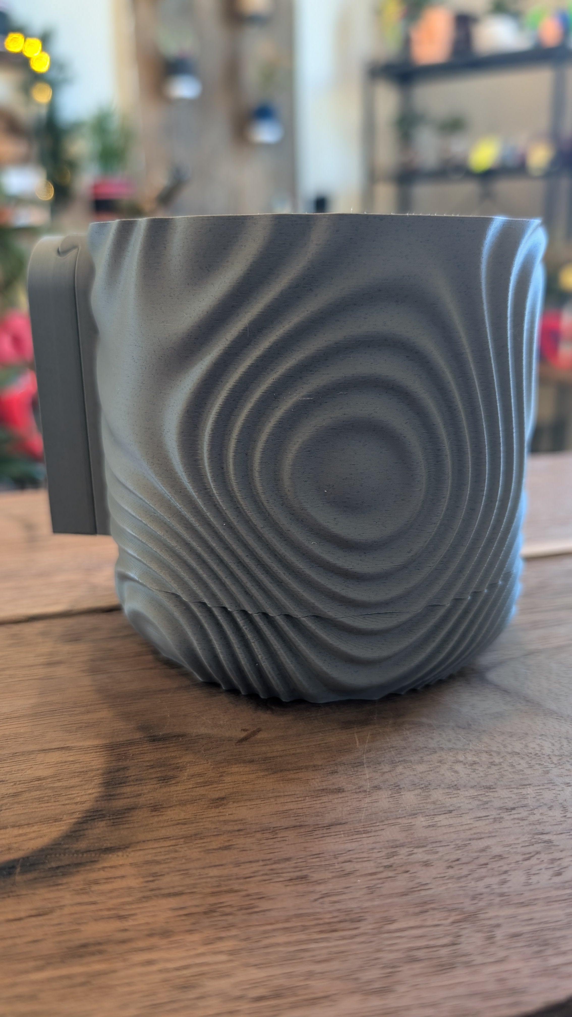 3D printed wall planter mounted on wall holding indoor plant
